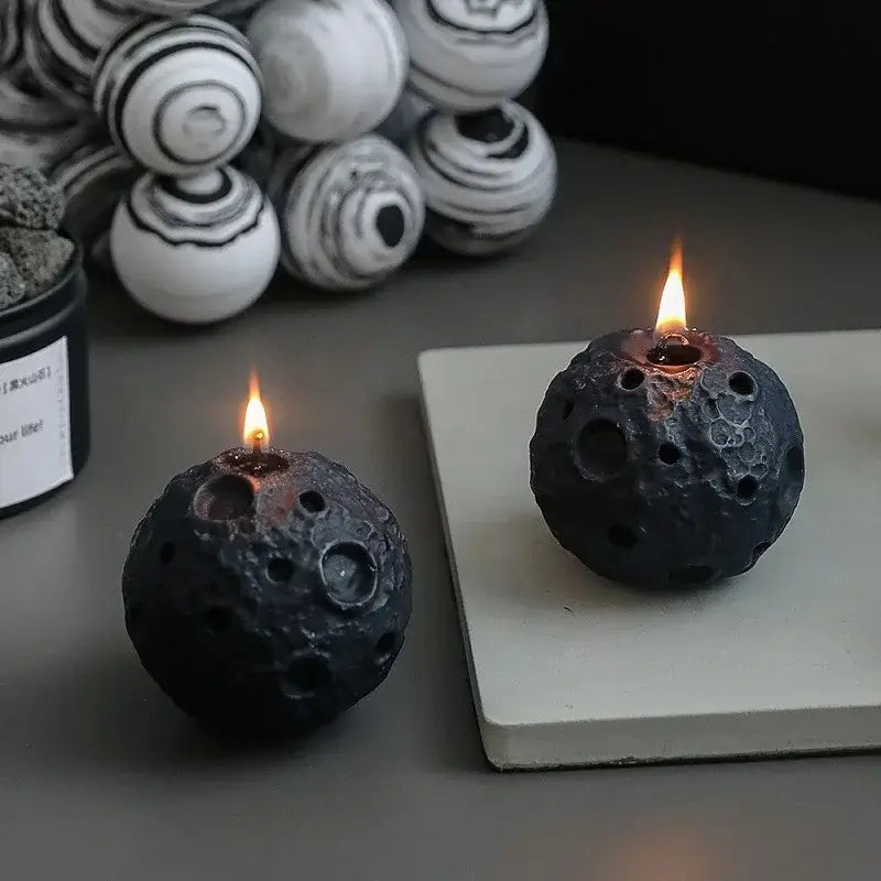 Bougie parfumée géométrique météorite noire allumée, idéale pour décoration intérieure moderne et apaisante.