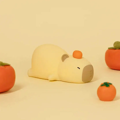 Adorable Capybara LED night light with soft, soothing glow surrounded by decorative fruits for a playful touch in any room.