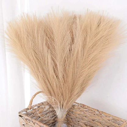 Bouquet de tiges de pampas beige dans un panier en osier pour décoration élégante et naturelle.
